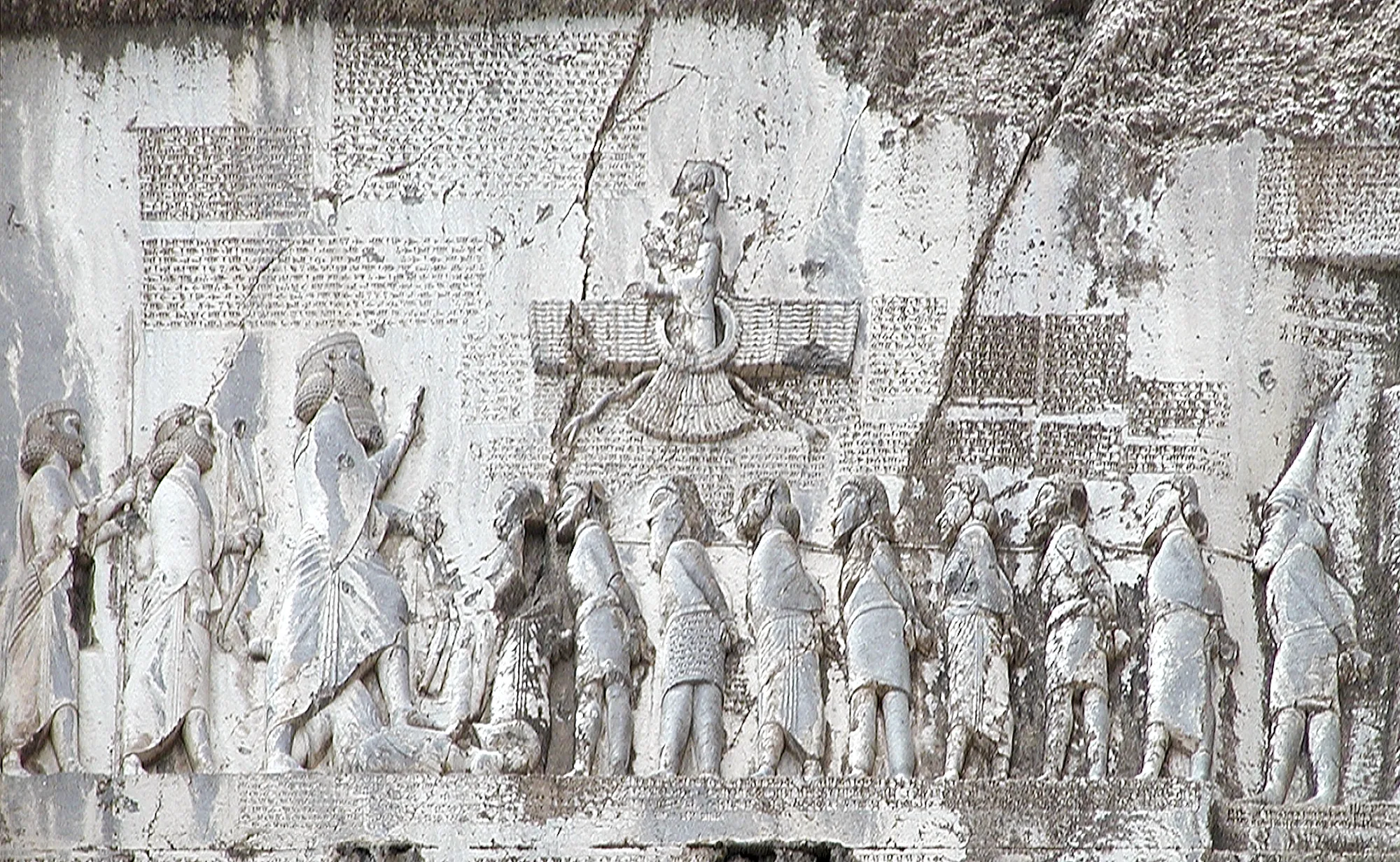 The Behistun rock relief seen from the front: King Darius under a winged figure, facing a line of bound rebels