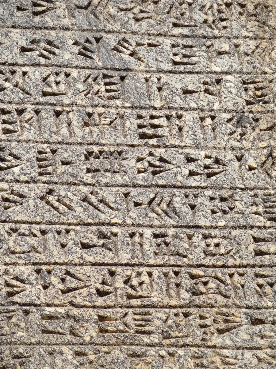 Close-up of deep cuneiform wedges cut into granite in a royal inscription at Ganjnameh